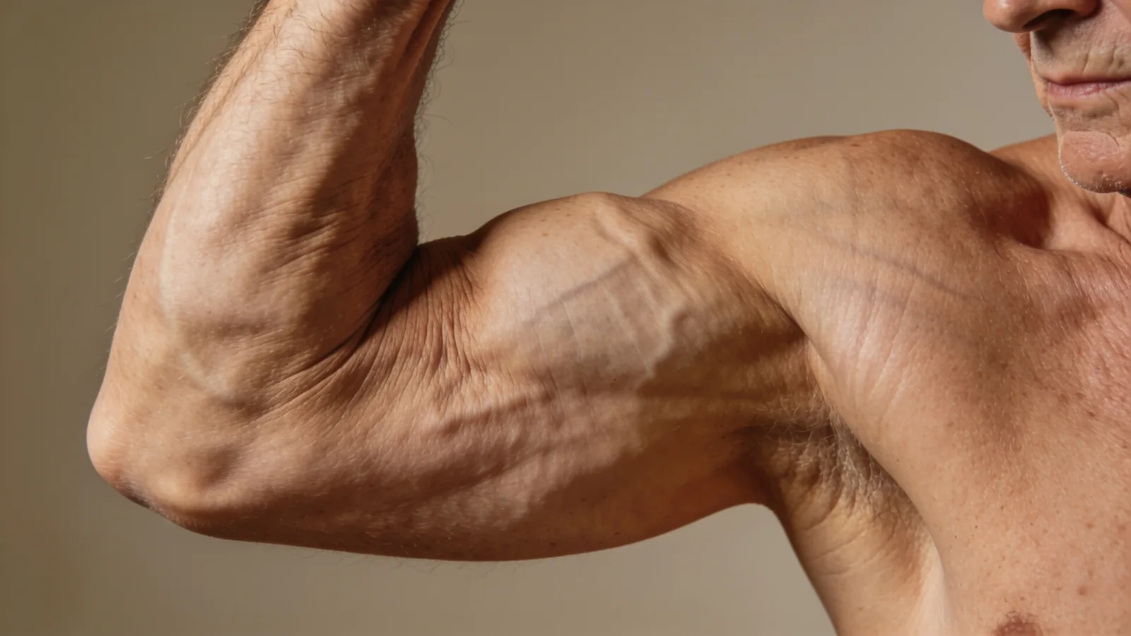 Older man flexing a lean, veiny biceps muscle, illustrating muscle building supported by daily leucine intake